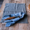 Palinopsia linen napkin with Laguiole cutlery on timber dining table