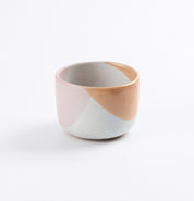 Handmade ceramic tumbler cup with two-tone design on a white background