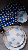 3 Piece blue and white dinner set on a stone bench top, dinner plate, lunch plate and small cereal bowl with a blue and white check table napkin