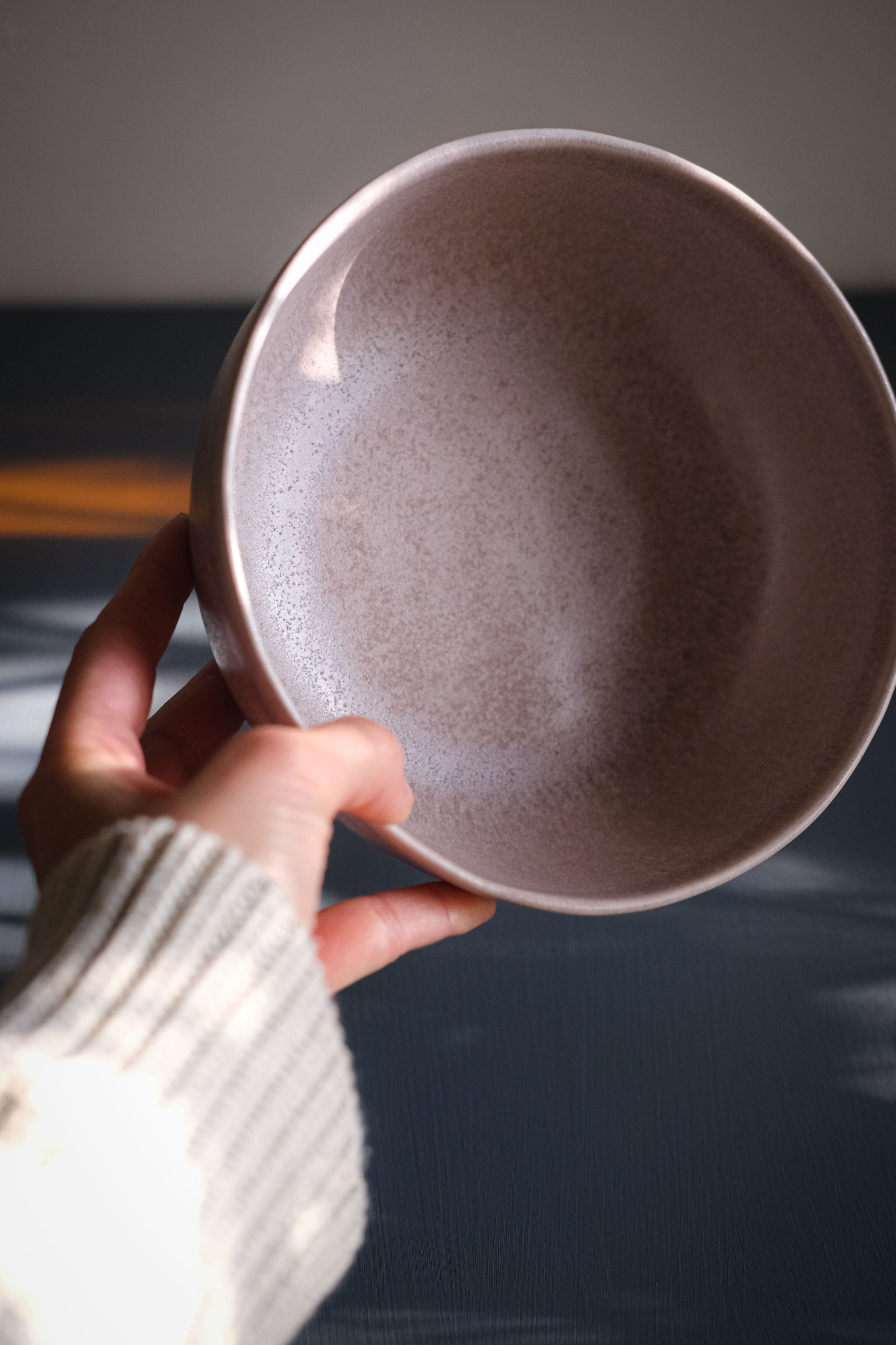 Hand holding a handmade stoneware breakfast bowl in mushroom glaze by Palinopsia Ceramics Sydney 