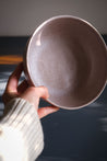 Hand holding a handmade stoneware breakfast bowl in mushroom glaze by Palinopsia Ceramics Sydney 