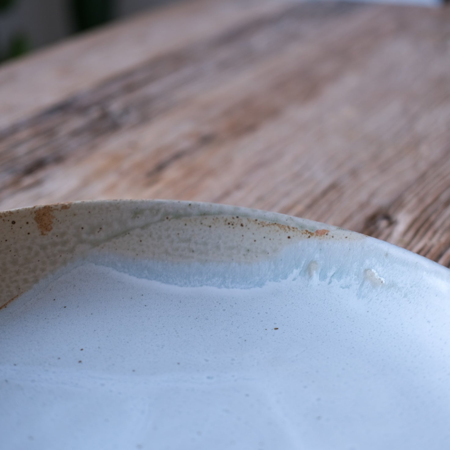 Detailed shot of a round large low serving platter in two tone brown and blue, handmade stoneware by Palinopsia ceramics 