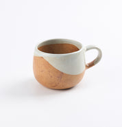 Two-toned soda fired ceramic mug in blue and brown, with a white top and brown bottom on a white background
