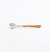 Ceramic teaspoon with two tone blue and brown colours on a white background