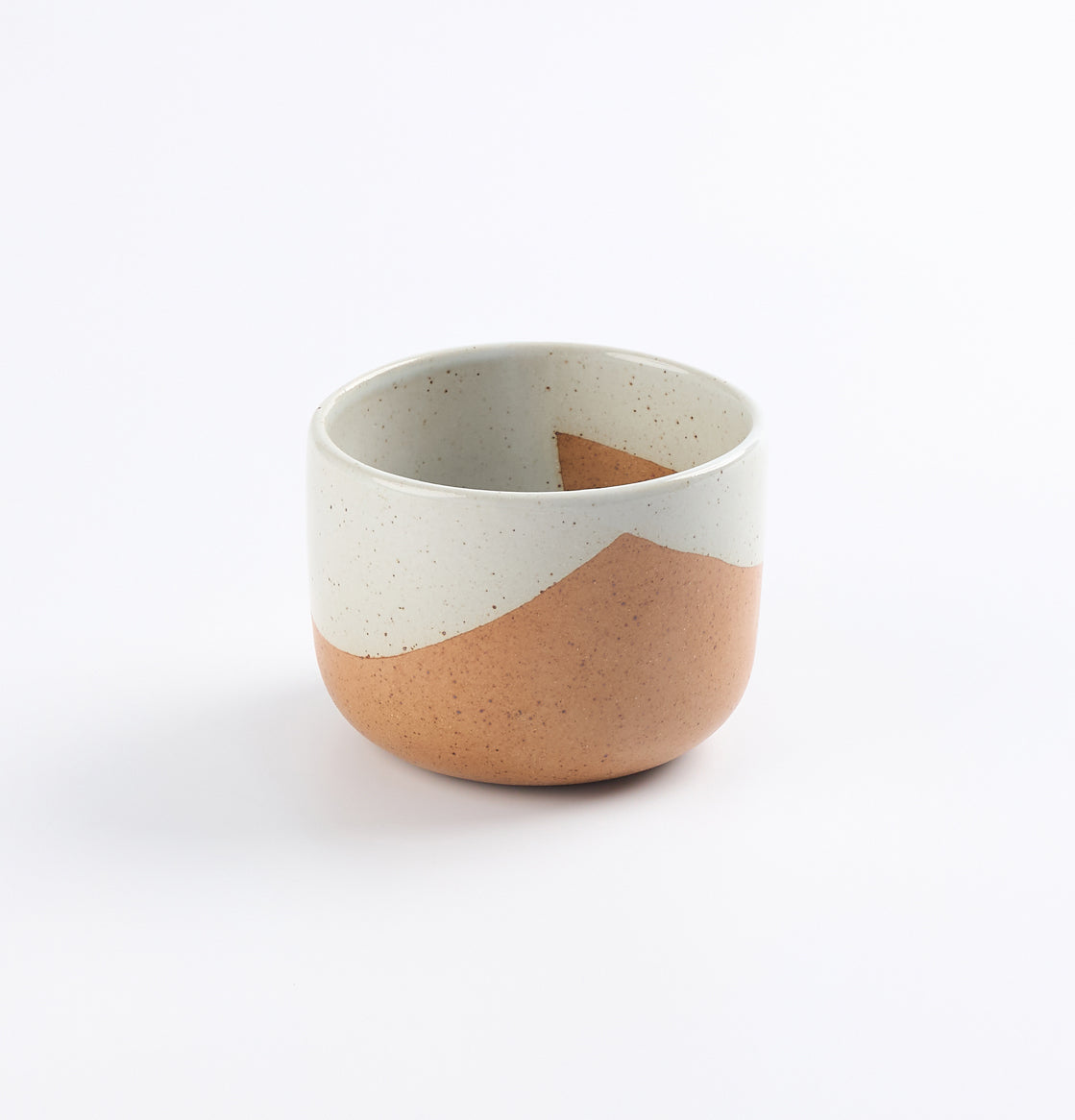 Ceramic stoneware cup with two-tone blue and brown design on a white background
