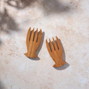 Bird’s-eye view of a set of teak wooden salad serving forks on a light stone background.