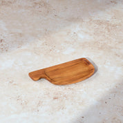 Palinopsia teak wooden small rectangular serving tray with a handle on a light stone background.