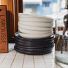 Monochrome dinnerware set by Palinopsia Ceramics with handmade black plates and white pasta bowls stacked in Palinopsia Darby St Ceramic Store 