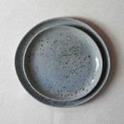 Bird's-eye view of a 2 piece handmade dinner set on a white tablecloth 