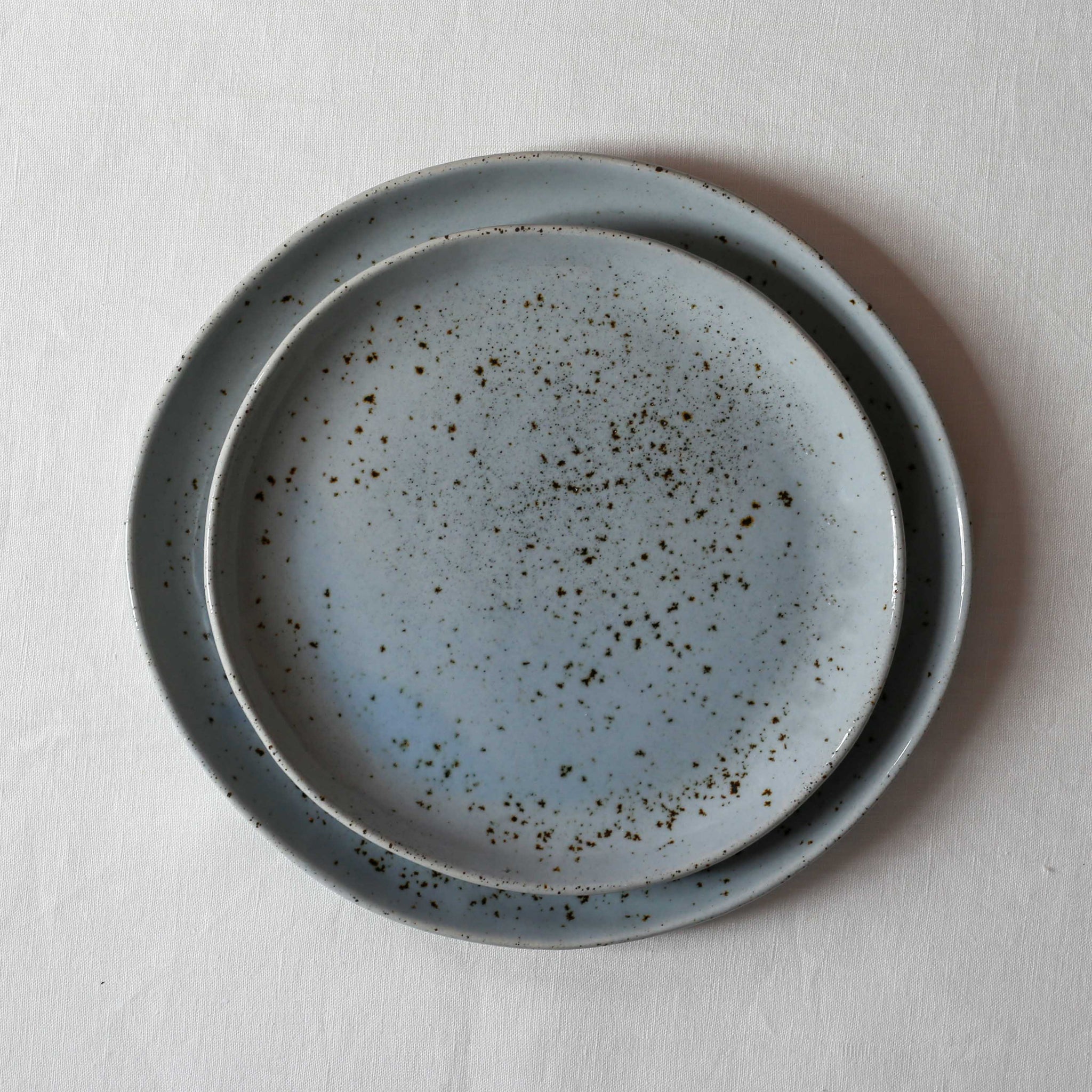 Handmade dinner plate and lunch plate in a blue speckle by Palinopsia ceramics 