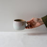 Hand holding a handmade mug