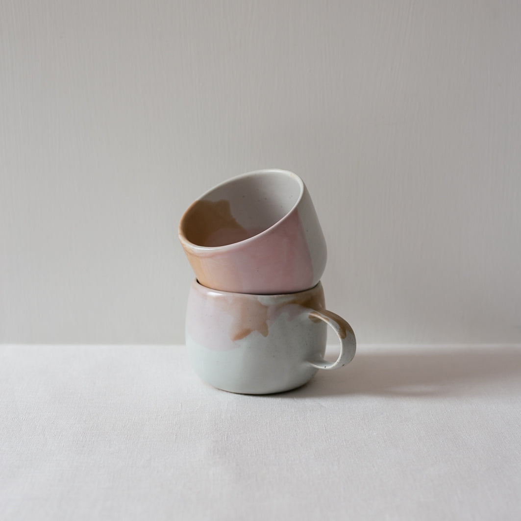 Stacked coffee and tea cup in colourful mix of pink, chocolate and white glazes