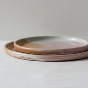 Closeup of a handmade plate by Palinopsia Ceramics in pinks, brown and white