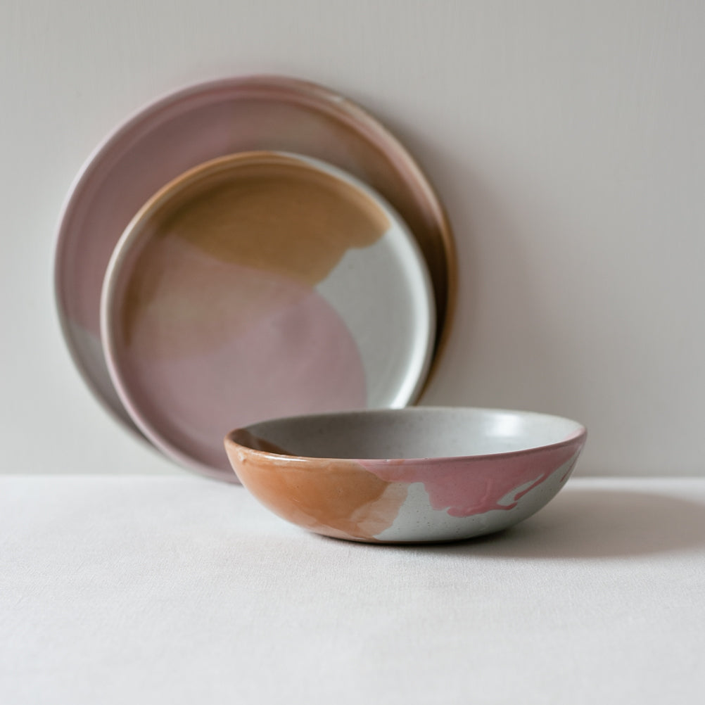 Payton dinnerware set by Palinopsia Ceramics, image focuses on the breakfast bowl with drippy glaze in pink, brown and grey  