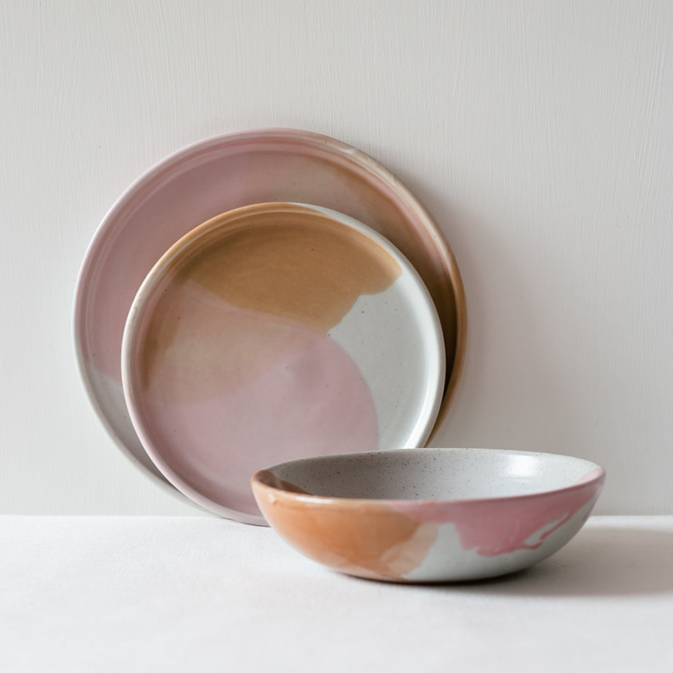 Handmade stoneware set by Palinopsia Ceramics in Pink, Brown and white. Here a Dinner plate, dessert plate and breakfast bowl are displayed on a white background