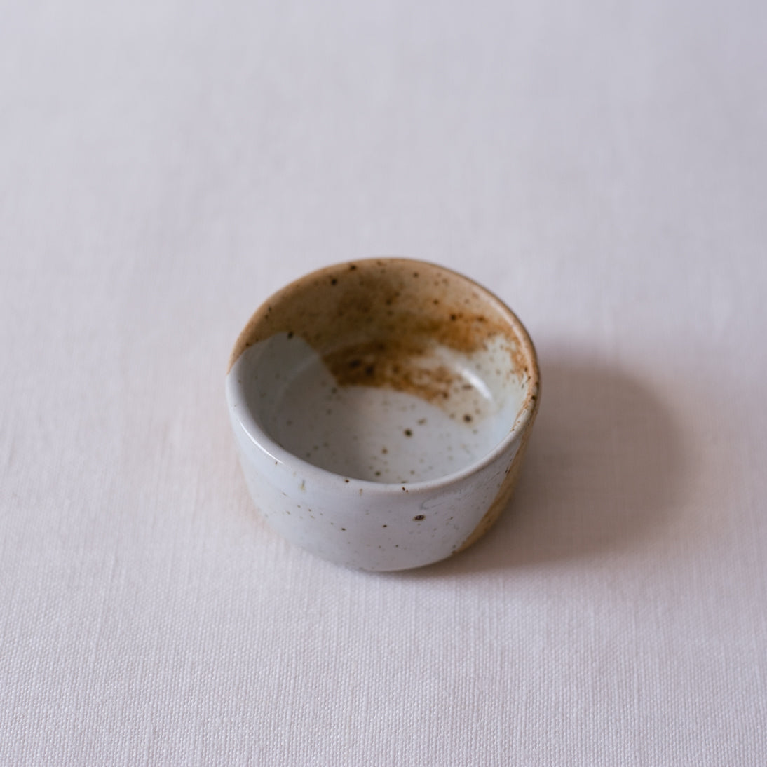 Detailed shot of speckled small little ceramic dish By Palinopsia