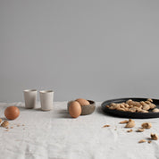 Handmade 26cm black dinner plate by Palinopsia ceramics in a still life photo in Sydney Australia 