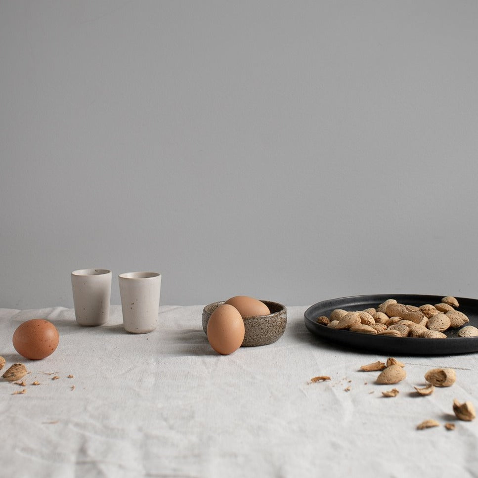 Handmade 26cm black dinner plate by Palinopsia ceramics in a still life photo in Sydney Australia 