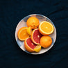Palinopsia fruit bowl with citrus on a blue linen tablecloth 