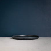 Side view of single Palinopsia Ceramics handmade flat Black Dinner Plate in Sydney Australia 