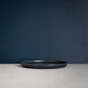 Side view of single Palinopsia Ceramics handmade flat Black Dinner Plate in Sydney Australia 