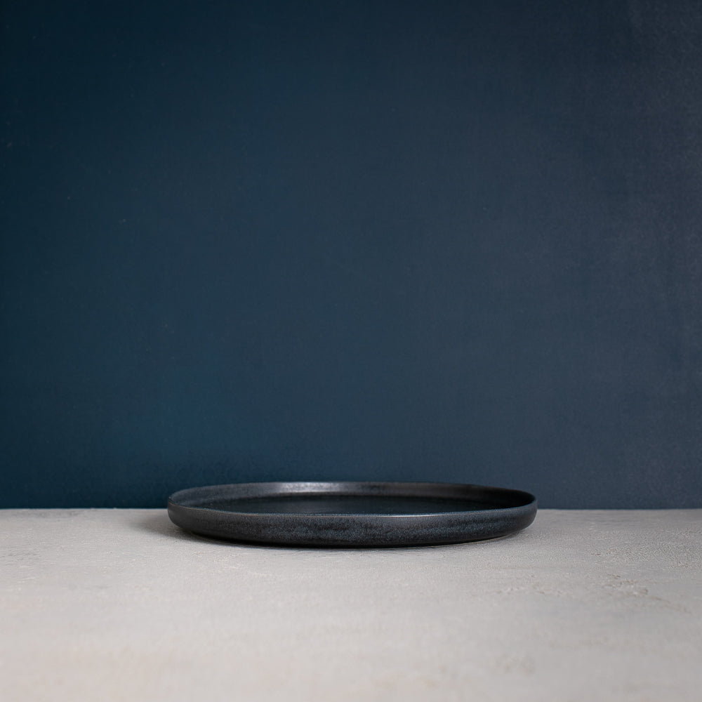 Side view of a Handmade Black dinner plate made with reactive glaze by Palinopsia Ceramics in Sydney Australia  