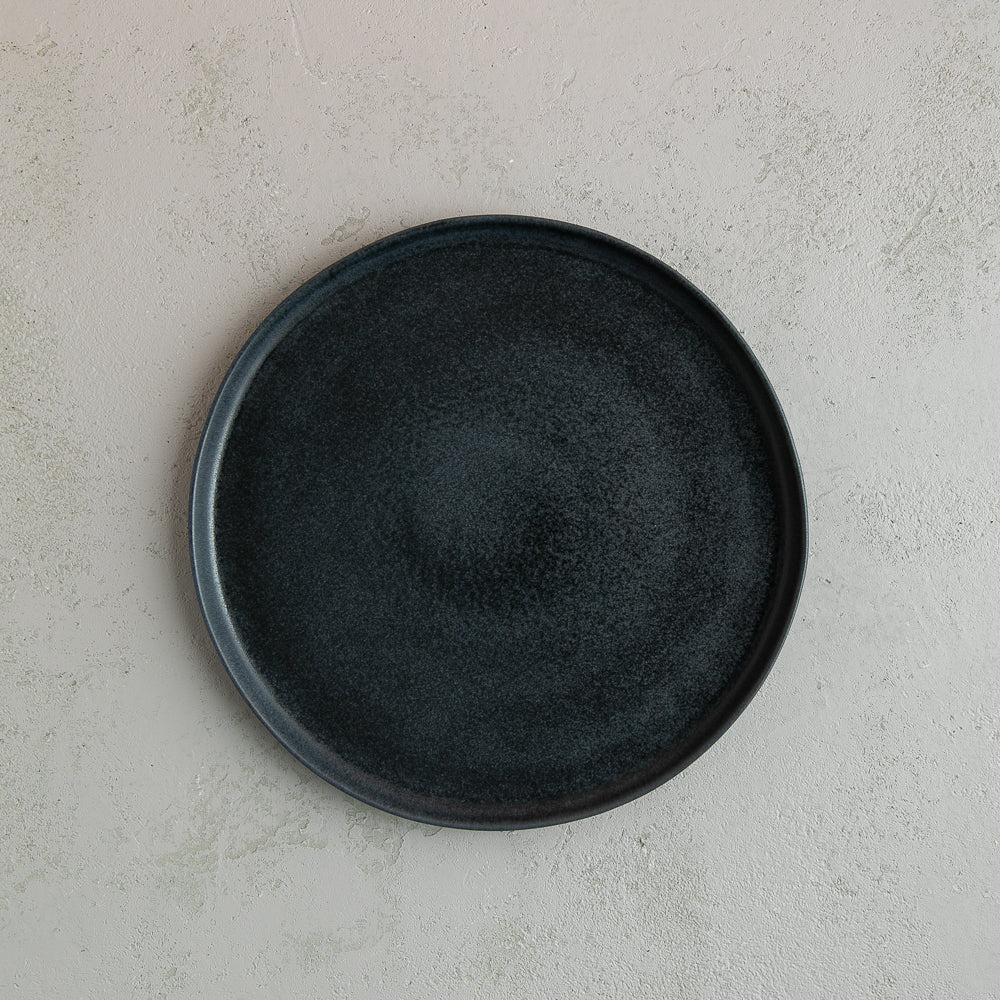 Birds-eye view of a 26cm Handmade black dinner plate with raised lip by Palinopsia Ceramics 