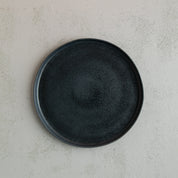 Birds-eye view of a 26cm Handmade black dinner plate with raised lip by Palinopsia Ceramics 