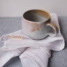 Handmade mug and pinstripe linen napkin by Palinopsia Ceramics